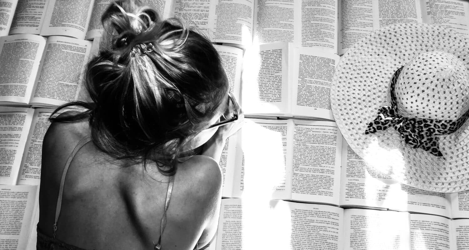 Mujer rodeada de libros en una imagen sobre literatura lésbica