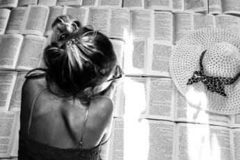 Mujer rodeada de libros en una imagen sobre literatura lésbica